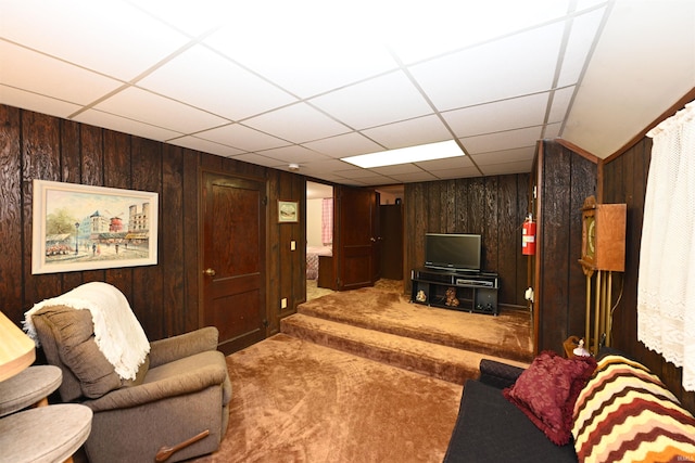 carpeted living room with a paneled ceiling and wooden walls