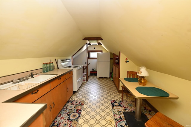 interior space with sink, vaulted ceiling, light tile patterned flooring, and white appliances