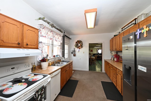 kitchen featuring sink, carpet, and white appliances