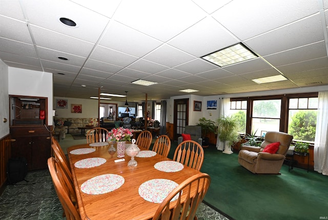 dining area with a paneled ceiling and carpet floors