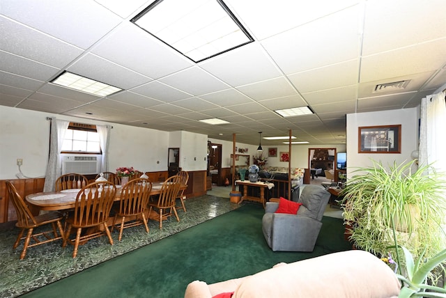 carpeted dining space with cooling unit and a drop ceiling