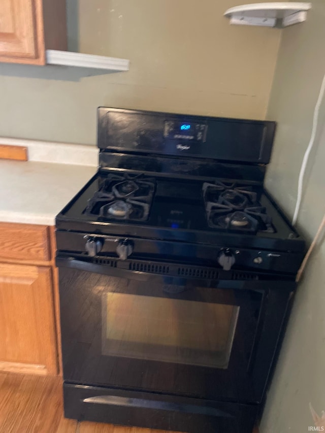 interior space with black gas stove and hardwood / wood-style floors