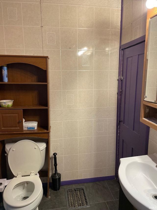 bathroom featuring tile walls, sink, tile patterned floors, and toilet