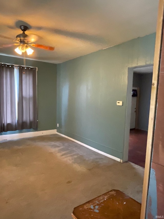 unfurnished room featuring ceiling fan and carpet