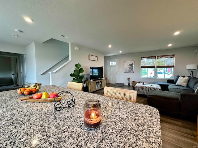 kitchen with hardwood / wood-style flooring and light stone counters