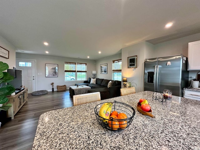 kitchen with dark hardwood / wood-style flooring, stainless steel fridge with ice dispenser, white cabinetry, and light stone counters