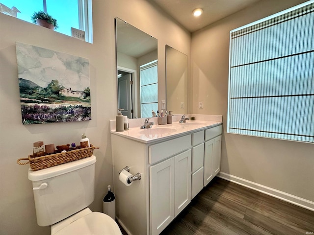 bathroom with toilet, hardwood / wood-style floors, and double vanity