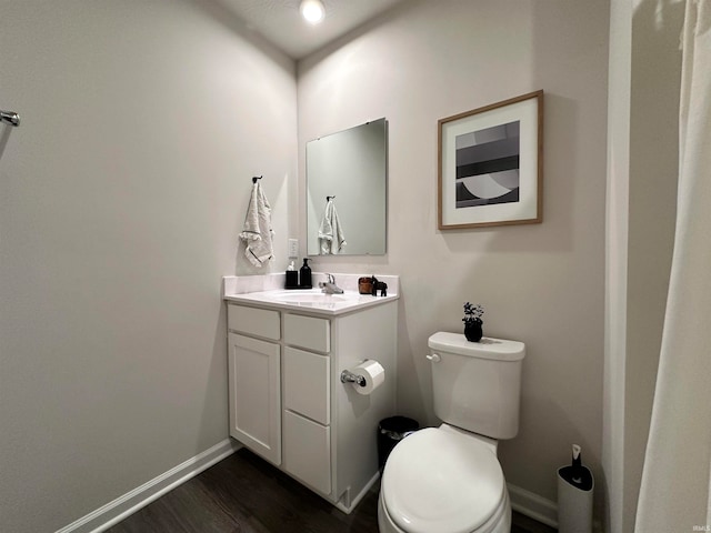 bathroom featuring toilet, hardwood / wood-style flooring, and vanity