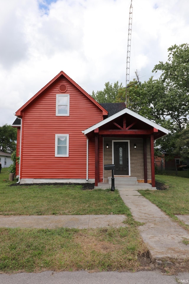 view of front of property featuring covered porch and a front yard