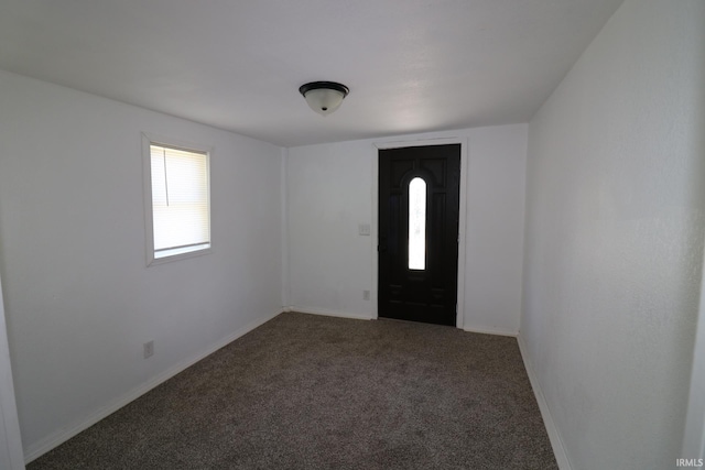 foyer featuring carpet and baseboards