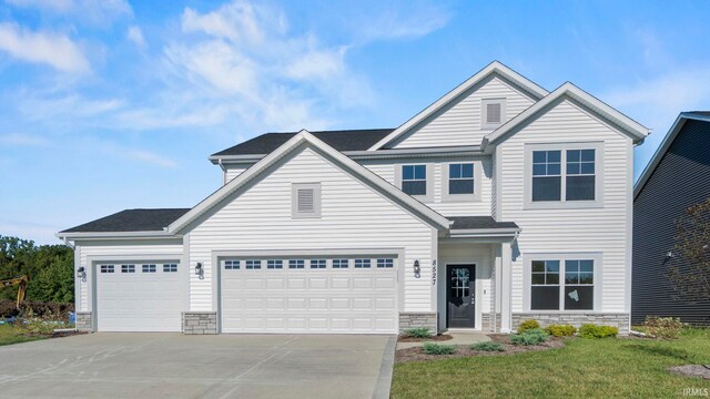 view of front of home with a front lawn and a garage