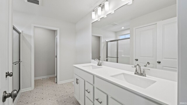 bathroom with dual vanity, tile patterned floors, and a shower with shower door