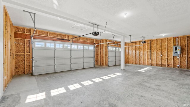 garage with a garage door opener and electric panel