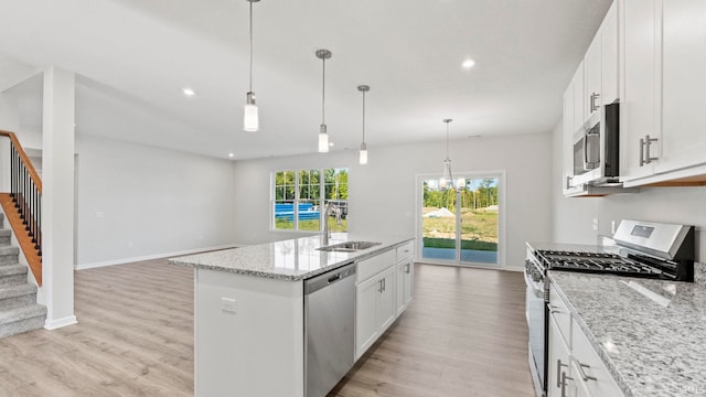 kitchen featuring white cabinets, light hardwood / wood-style floors, an island with sink, and stainless steel appliances