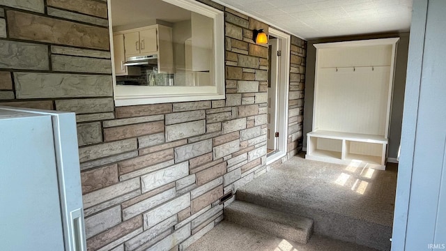 interior space with light carpet and wood walls