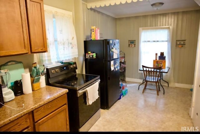 kitchen with a healthy amount of sunlight, electric range, and black fridge