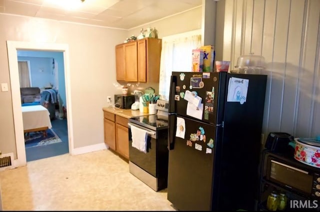 kitchen with black fridge and stainless steel range with electric cooktop