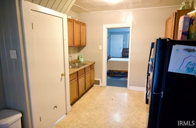 kitchen featuring sink and black fridge