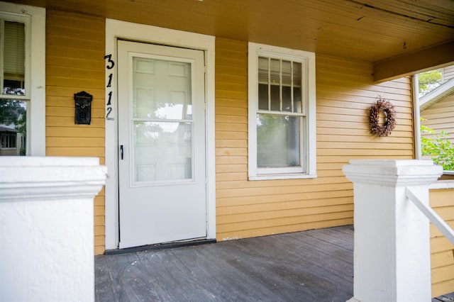 view of exterior entry featuring covered porch