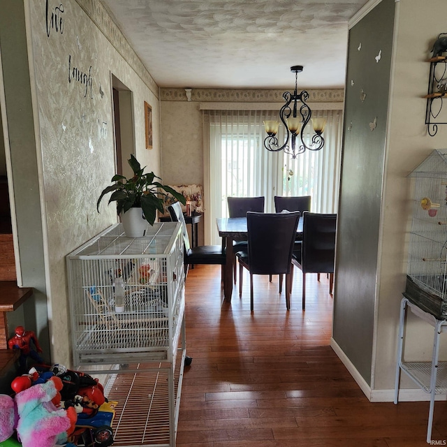 dining space featuring hardwood / wood-style flooring, an inviting chandelier, and a textured ceiling