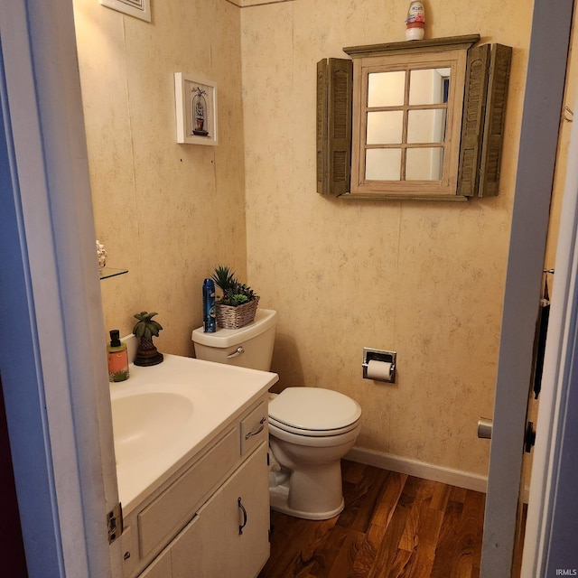 bathroom with wood-type flooring, toilet, and vanity