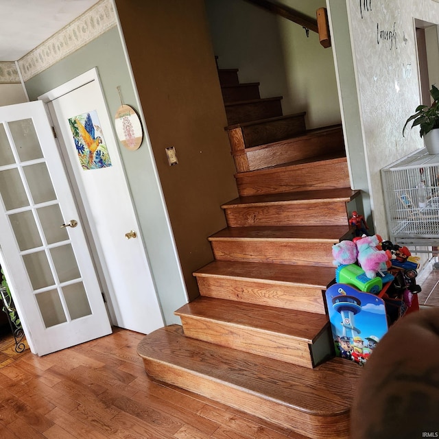 staircase featuring french doors and wood-type flooring