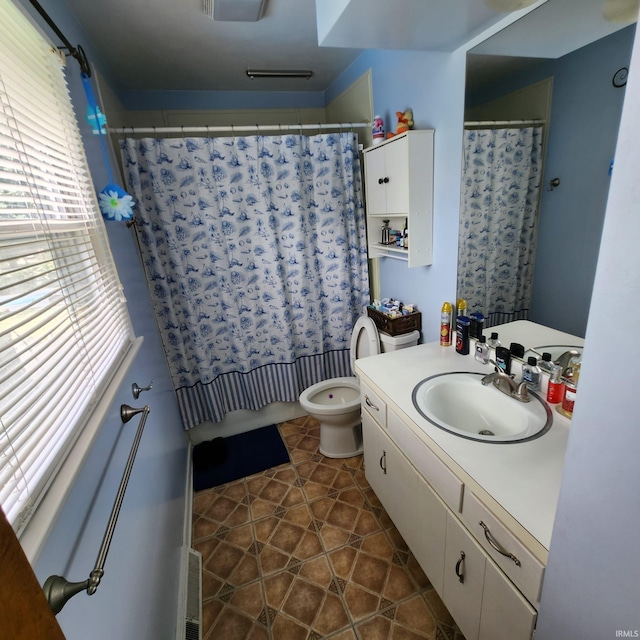 bathroom featuring a wealth of natural light, tile patterned flooring, vanity, and toilet