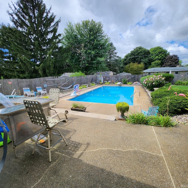 view of swimming pool featuring a diving board and a patio