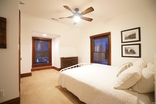 bedroom featuring a ceiling fan, light colored carpet, visible vents, and baseboards