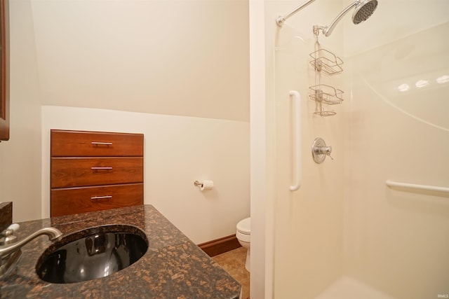 bathroom featuring toilet, a stall shower, tile patterned floors, and vanity