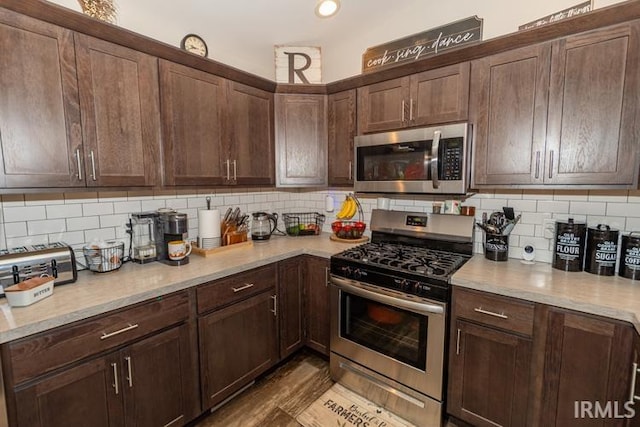 kitchen with appliances with stainless steel finishes, dark brown cabinetry, and tasteful backsplash