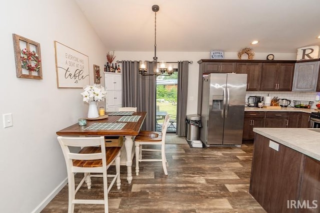 kitchen with stainless steel fridge, a chandelier, wood-type flooring, and tasteful backsplash