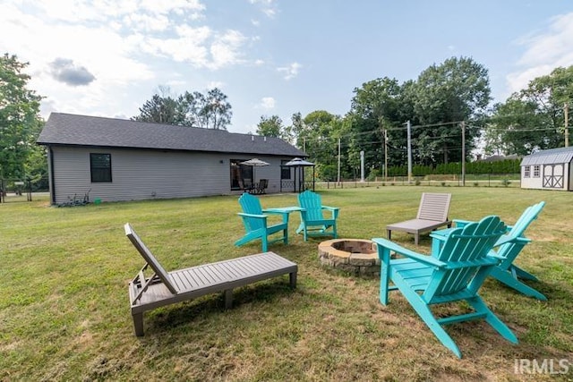 exterior space with an outdoor fire pit, a storage shed, and a yard