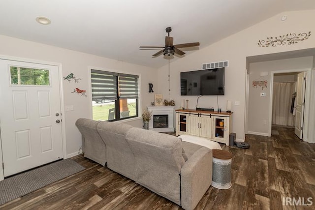 living room featuring vaulted ceiling, dark hardwood / wood-style flooring, and a healthy amount of sunlight