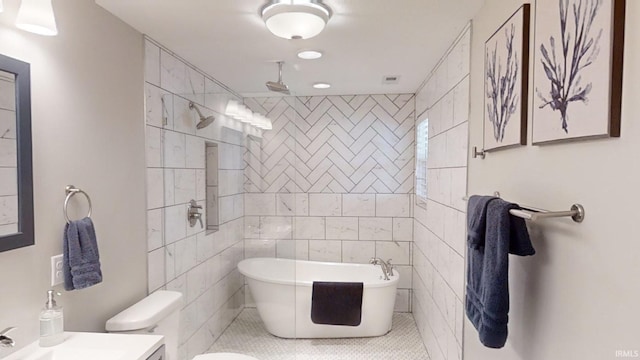 bathroom featuring a washtub, tile walls, toilet, and tile patterned floors