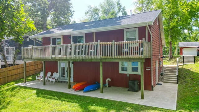 rear view of property with a patio area, central AC unit, and a lawn