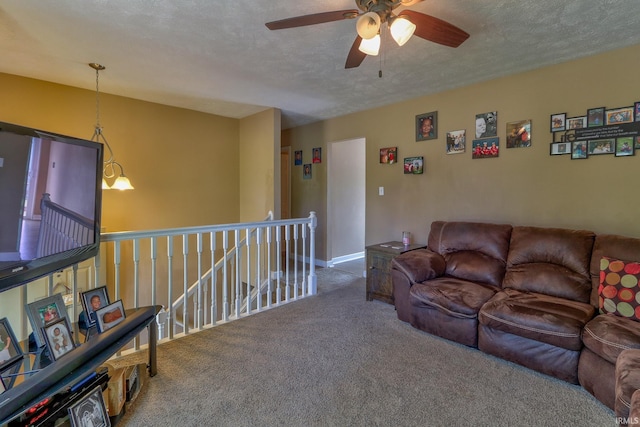 living room with a textured ceiling, carpet floors, and ceiling fan