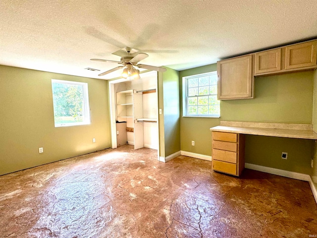 kitchen featuring a textured ceiling, ceiling fan, and light brown cabinets