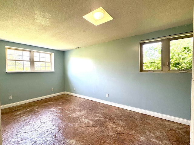 empty room featuring a textured ceiling and a healthy amount of sunlight