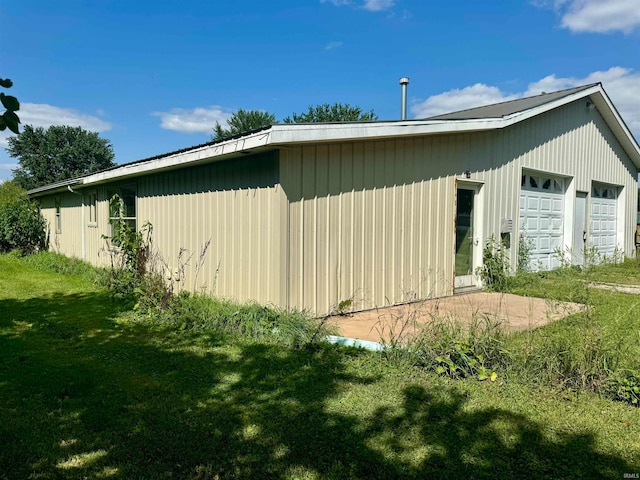 view of home's exterior with a garage and a lawn