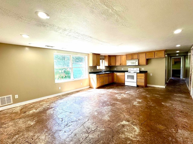 kitchen featuring sink, a textured ceiling, and white appliances