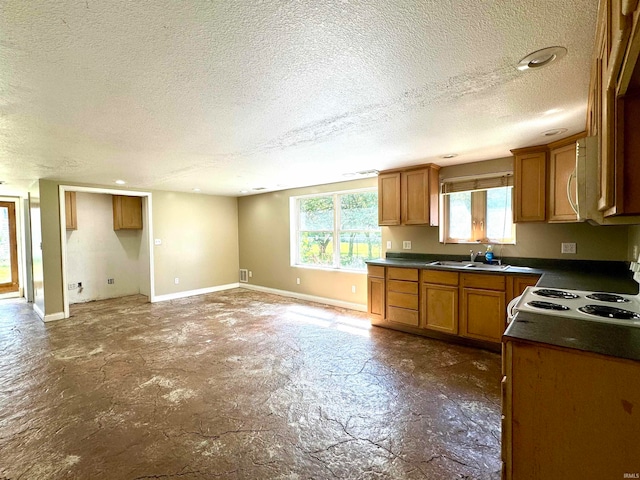 kitchen featuring sink, a textured ceiling, and electric range