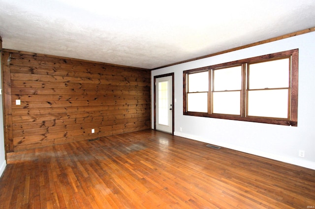 spare room featuring wood walls and hardwood / wood-style flooring