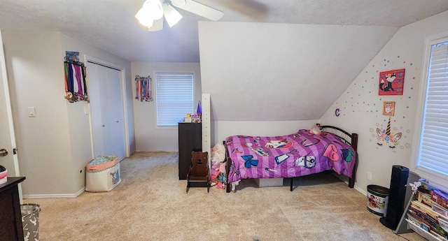 carpeted bedroom with a textured ceiling, ceiling fan, and lofted ceiling