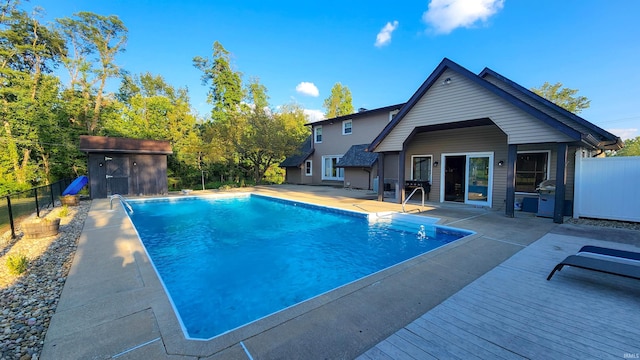 view of pool with a patio and an outbuilding