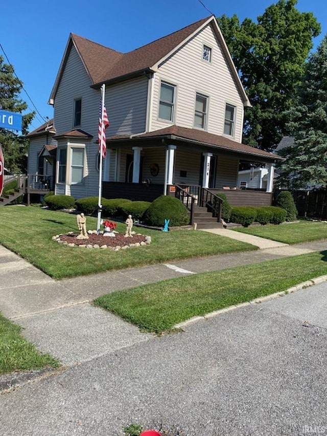 farmhouse with covered porch and a front yard