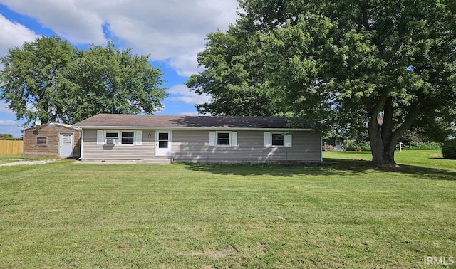 back of property with a yard and an outdoor structure