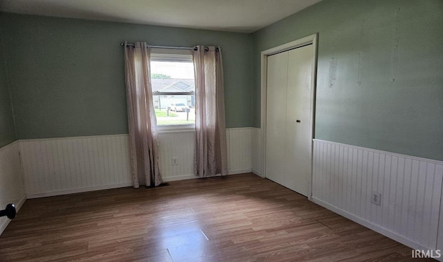 empty room featuring wainscoting and wood finished floors