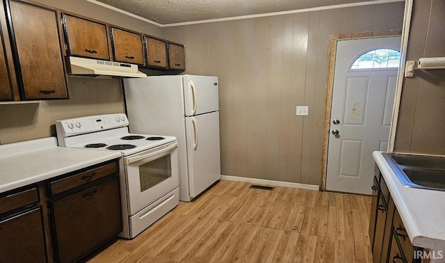 kitchen with electric stove, light countertops, crown molding, a textured ceiling, and under cabinet range hood