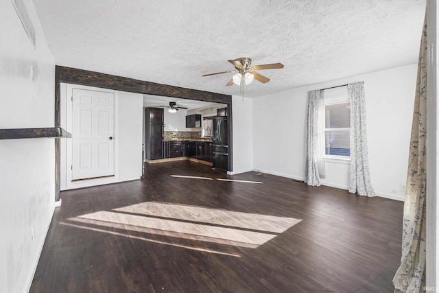 living room featuring a ceiling fan, baseboards, dark wood finished floors, and a textured ceiling